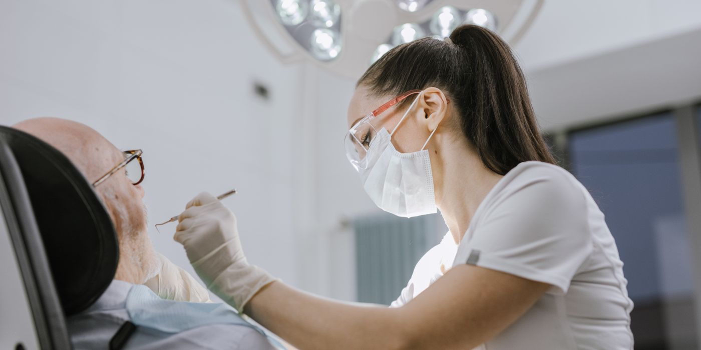 Female dentist working on a patient in a modern dental office with bright lighting.