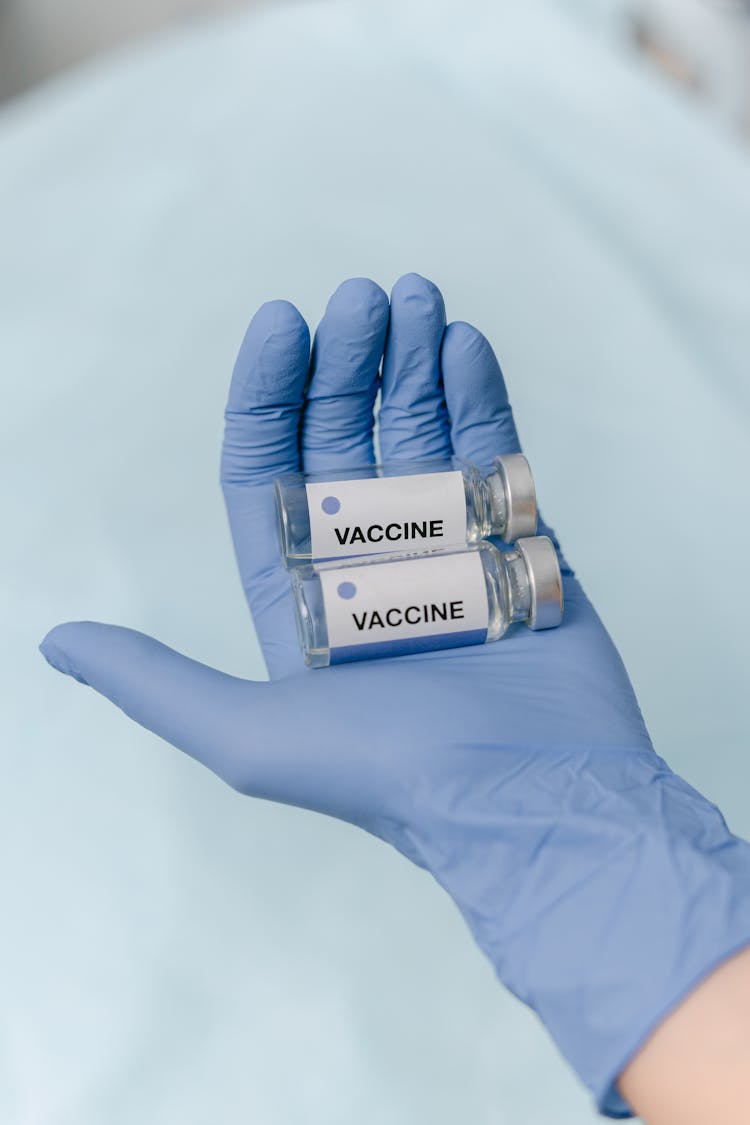 Vials Of Vaccine On A Hand 