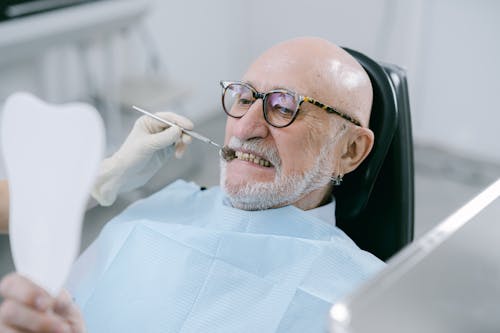Man Wearing Eyeglasses Sitting on Dental Chair