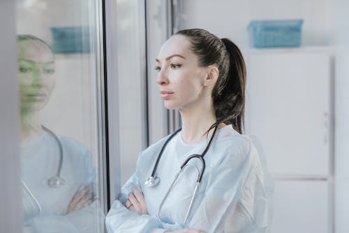 Free Female Doctor standing by the Window  Stock Photo