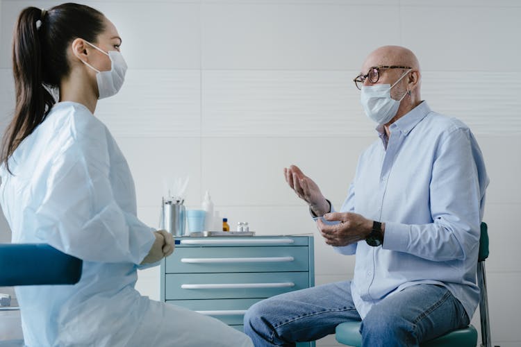 Elderly Man Patient Talking At His Doctor 