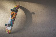 Multicolored Skateboard Leaning on Wall