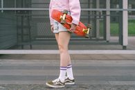 Person in Pink Dress Shirt and Blue and White Nike Sneakers
