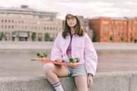 Woman in Pink Coat Holding Red and Gold Trumpet