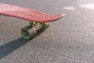 Red and Green Skateboard on Gray Asphalt Road