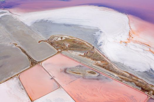 A breathtaking aerial shot capturing the vivid colors of expansive salt flats, showcasing nature's abstract beauty.