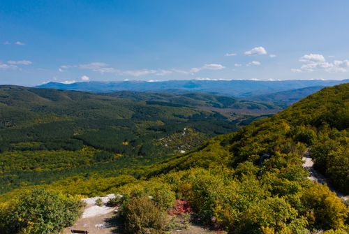 Free A breathtaking aerial shot showcasing lush green mountains under a clear blue sky. Stock Photo