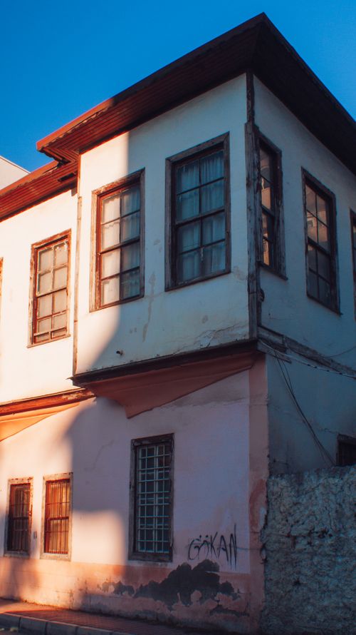 Free Charming vintage house exterior with wooden windows in warm light, showcasing rustic architecture. Stock Photo