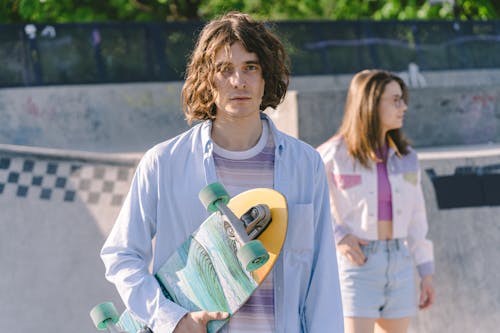 A Man Holding His Skateboard