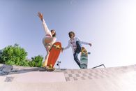 Man in White T-shirt and Brown Shorts Jumping on Gray Concrete Floor