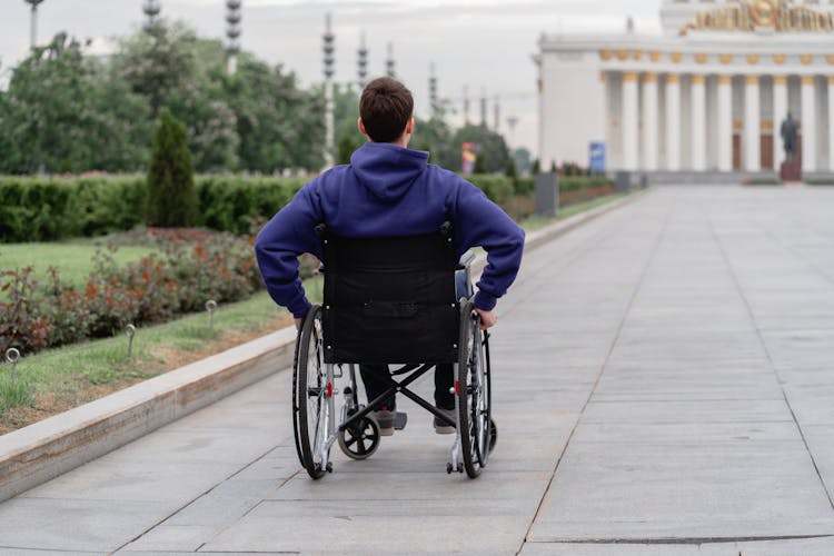 Back View Of A Man Sitting On A Wheelchair