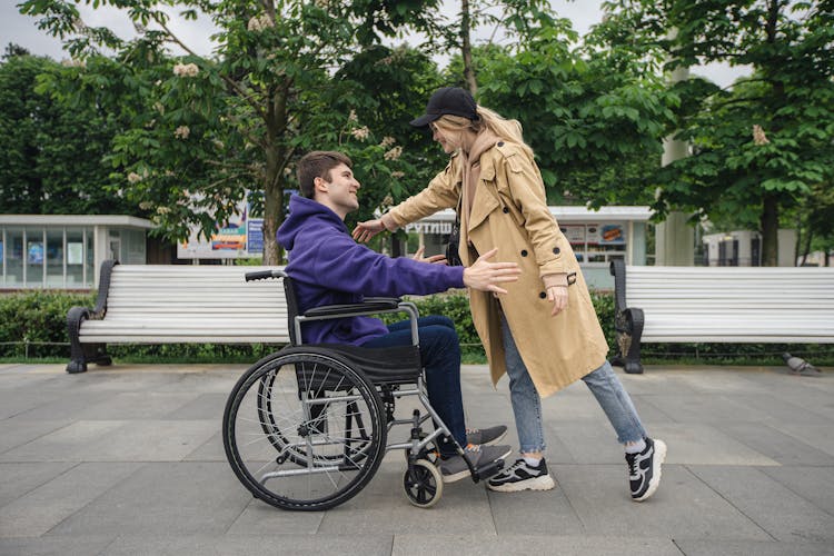 Woman Greeting Man On A Wheelchair