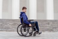Boy in Blue Hoodie Sitting on Black Wheelchair