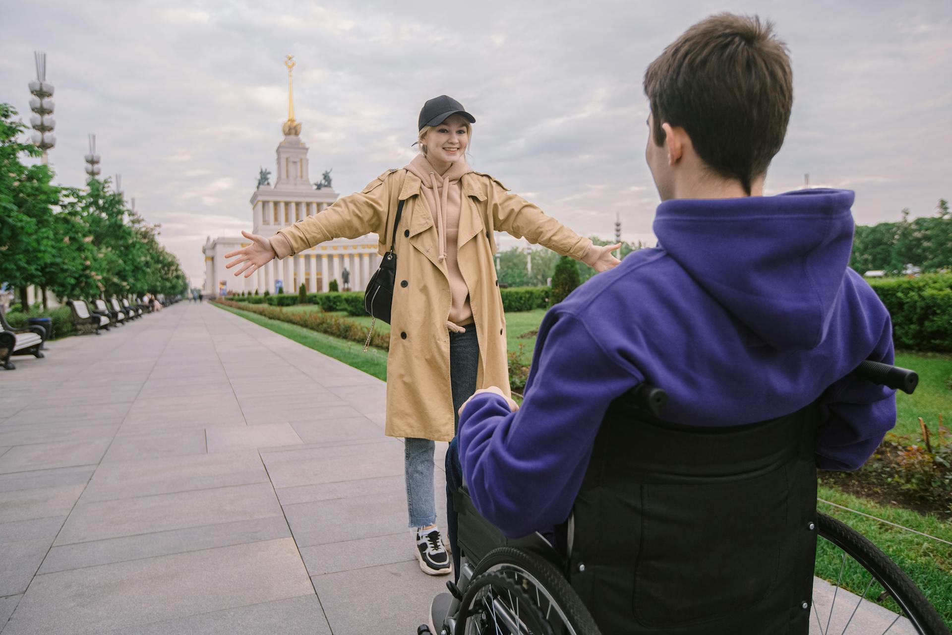 A joyful reunion between friends in a wheelchair-friendly park. Inclusive and uplifting.