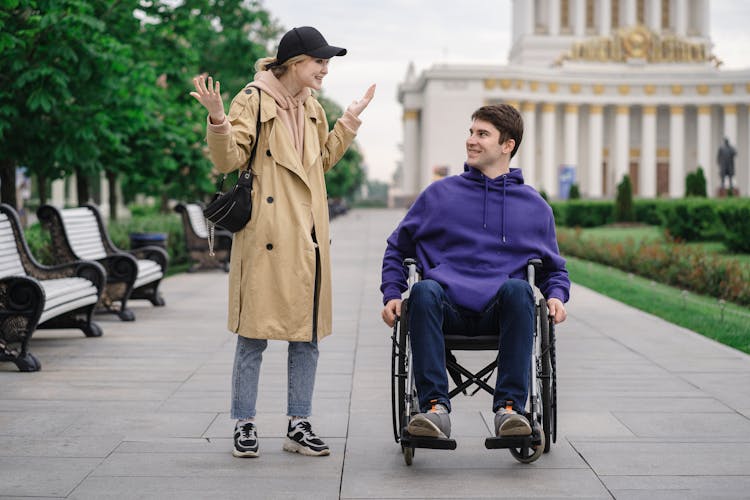 Woman Talking To A Man On A Wheelchair