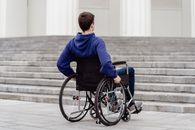Boy in Blue Sweater Sitting on Black Wheelchair