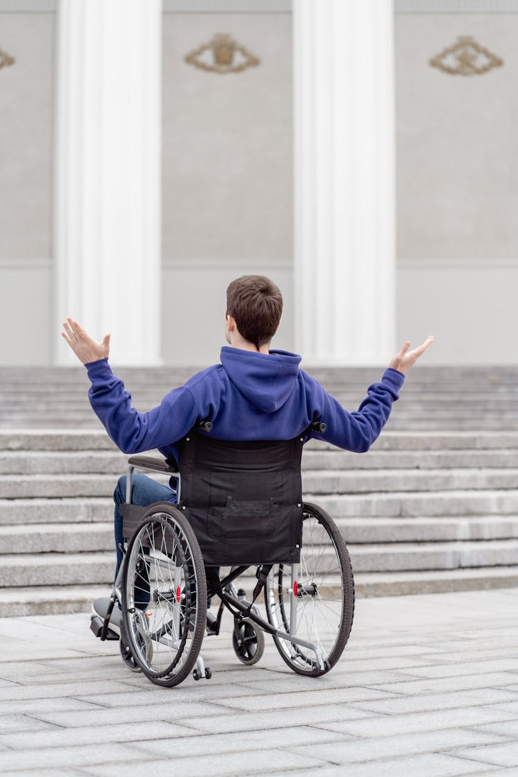 Back View Of A Man Sitting On A Wheelchair