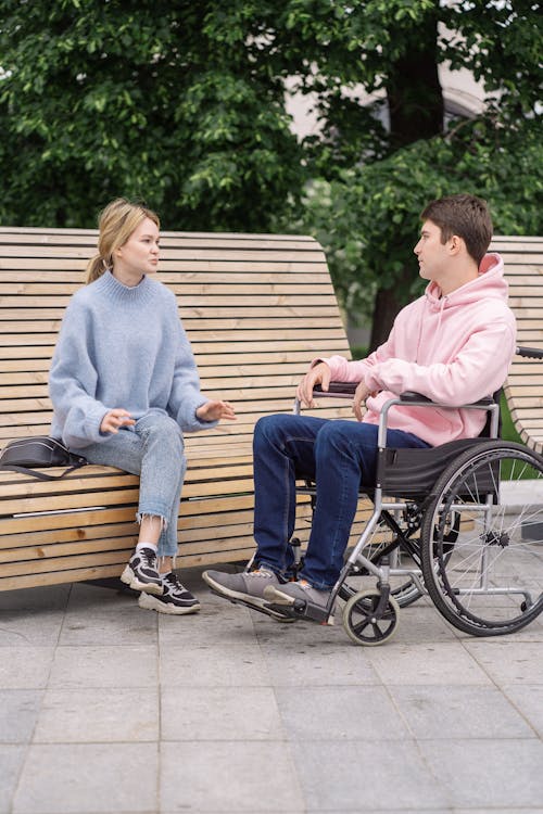 Free A Man Sitting on the Wheel Chair Talking the Woman Stock Photo