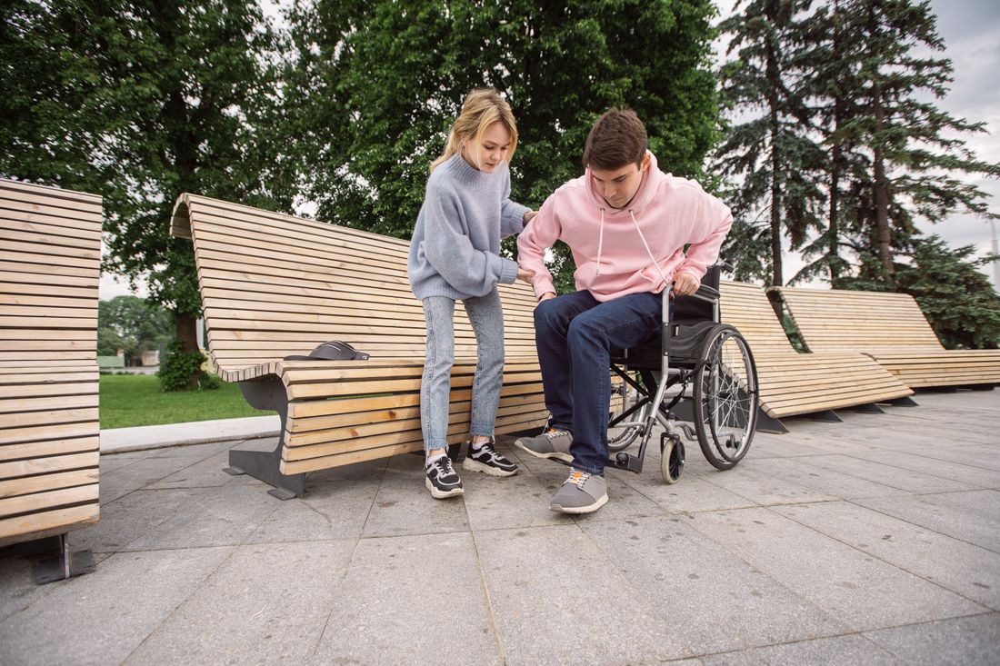 Support worker assisting a wheelchair user outdoors