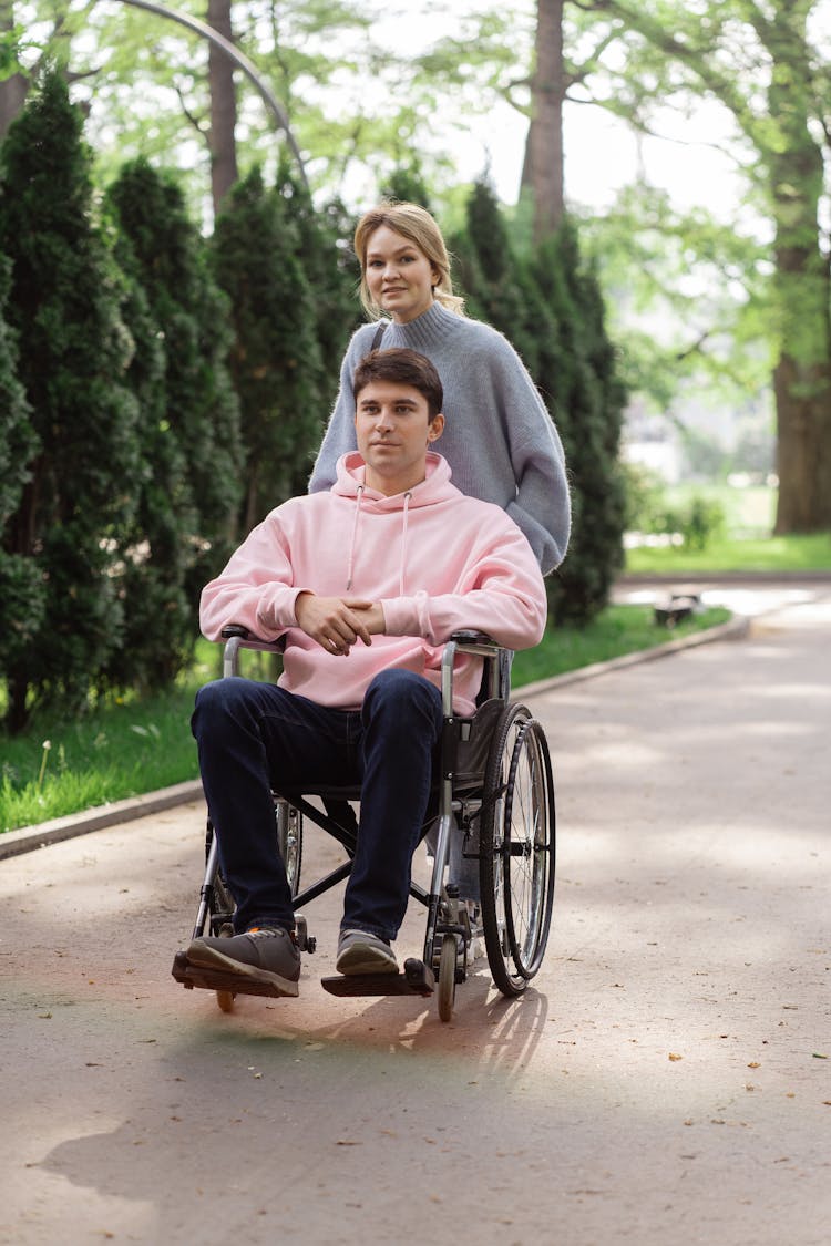 Woman Pushing The Wheelchair With A Man