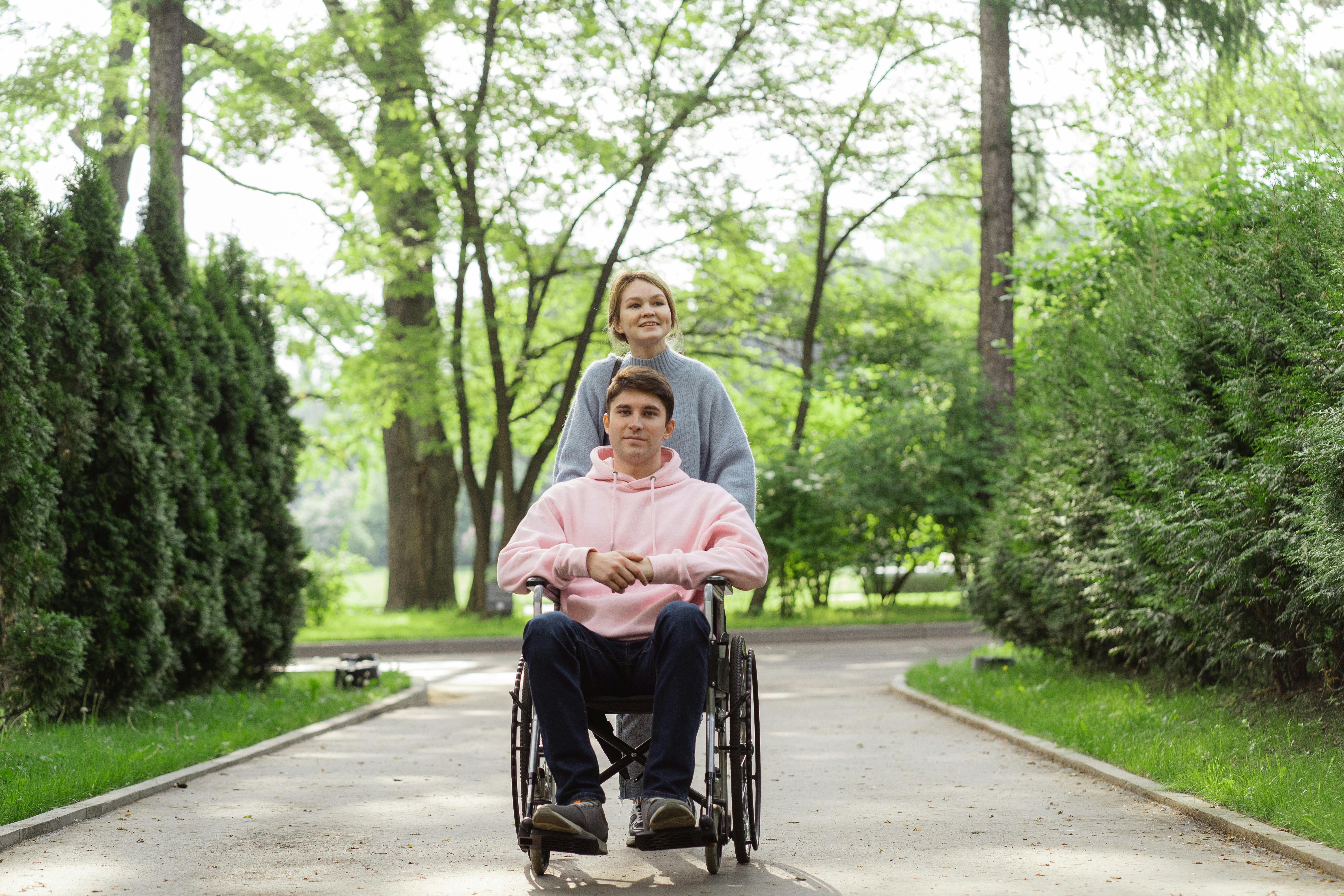 Woman Pushing The Wheelchair With A Man In The Park · Free Stock Photo