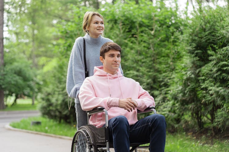 Woman Pushing The Wheelchair With A Man