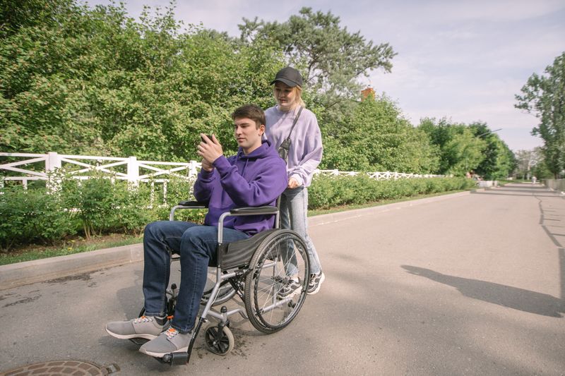 Nasmejani putnik u invalidskim kolicima sa pratnjom