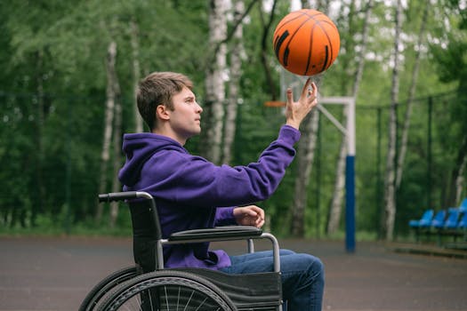 A man in a wheelchair skillfully spinning a basketball on his finger outdoors.