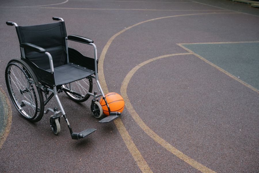 Fauteuil de sport et ballon de basket sur un terrain