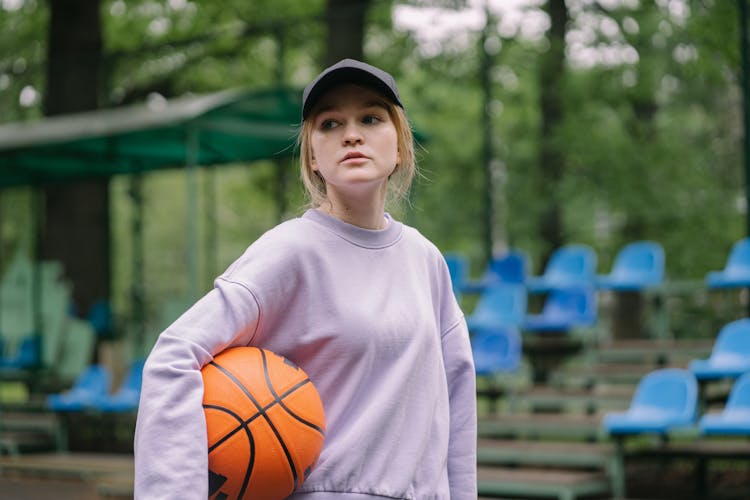 A Woman Wearing Black Cap While Holding Ball