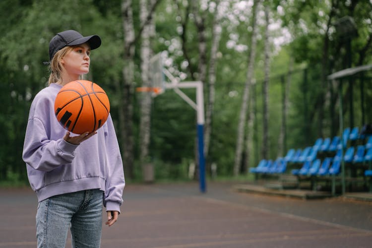 A Woman Wearing Black Cap While Holding Ball