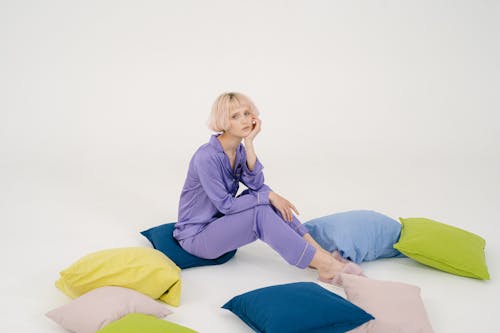Free Woman Wearing Sleepwear Sitting on Throw Pillow Stock Photo