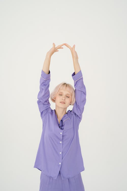 Free Woman in Purple Sleepwear Stretching Her Hands Stock Photo