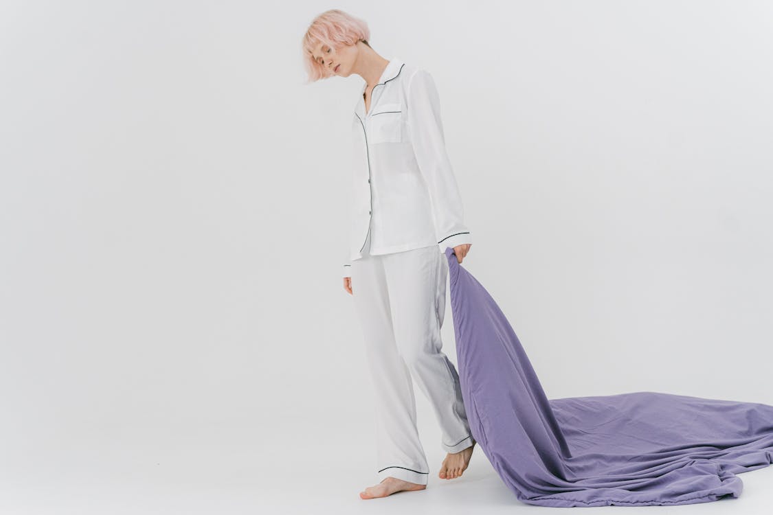 Free Woman in White Sleepwear Dragging a Purple Blanket Stock Photo