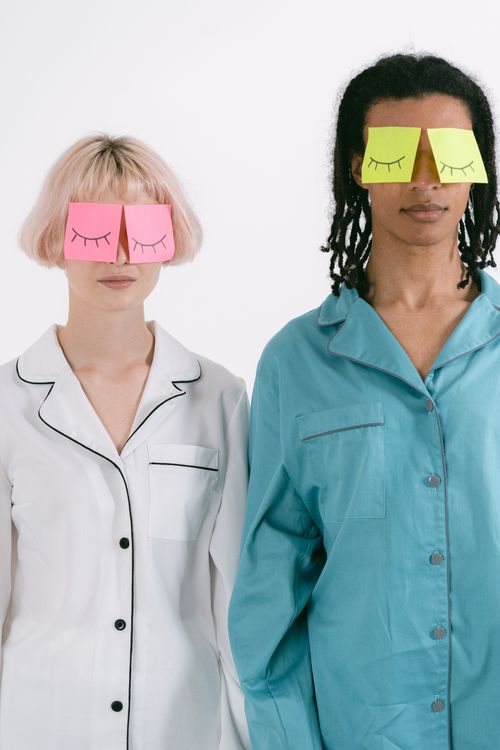 Free Two adults in colorful sleepwear with sticky notes on their faces, expressing creativity and fun. Stock Photo