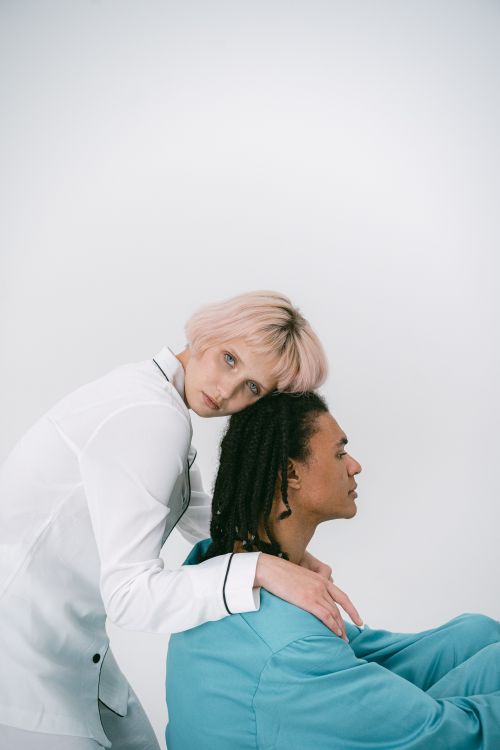 Free A woman and a man share a gentle embrace in a minimalist setting. Stock Photo