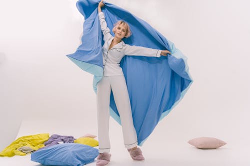 Free Woman Wearing Sleepwear Holding Blanket while Looking at the Camera Stock Photo