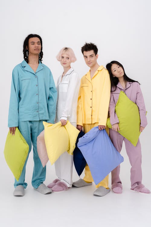 Free A Group of People Wearing Pajamas while Holding Pillows Stock Photo