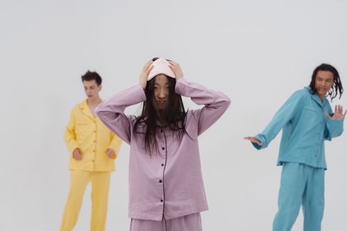 Free Three young adults in colorful pajamas showing expressive emotions in a studio setting. Stock Photo