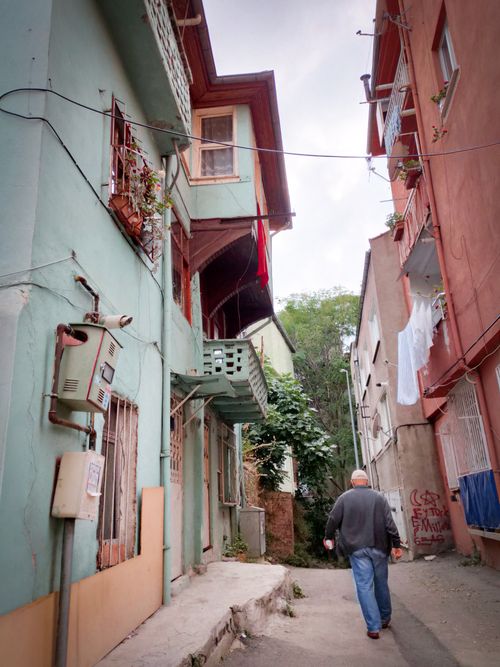 Free A man walks down a colorful alleyway lined with traditional houses in Bursa, Turkey. Stock Photo