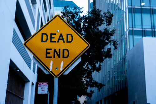 Free A clear dead end street sign amidst urban buildings, highlighting navigation caution in city settings. Stock Photo