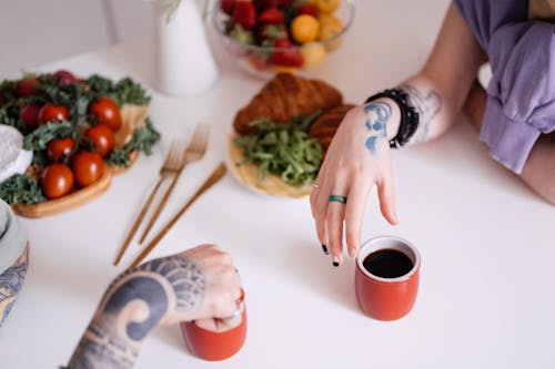 Free Women's Hands Beside Cups at Dinner Table Stock Photo