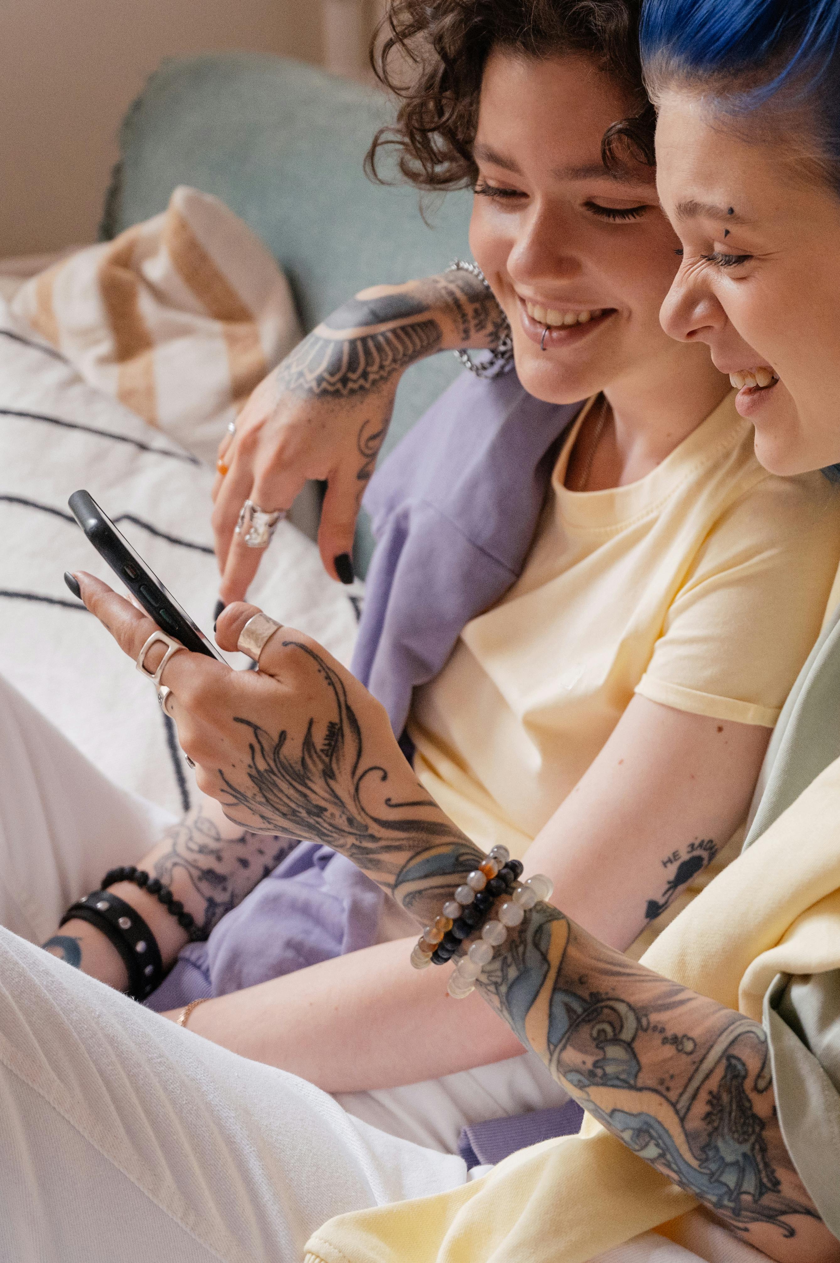 a same sex couple having conversation while looking at the phone