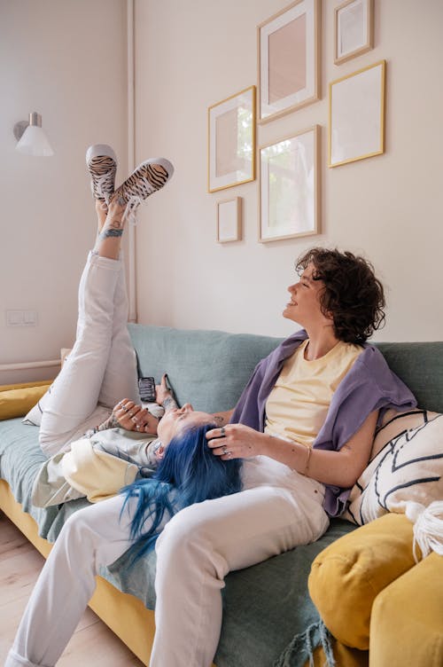 Free A Woman in Blue Hair Lying on the Couch Near Her Partner while Having Conversation Stock Photo