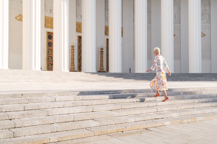 Woman In Printed Dress Walking On The Stairs