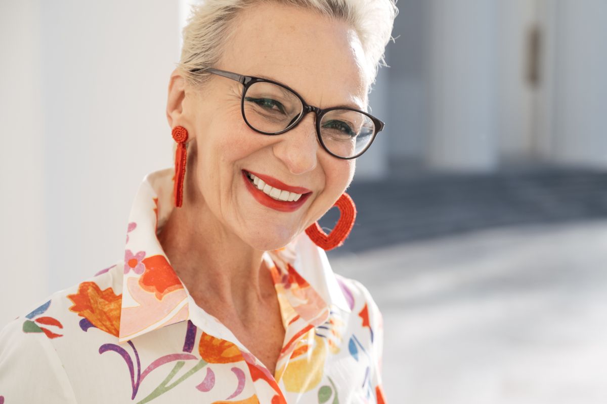 Woman smiling confidently after completing her dental implant treatment