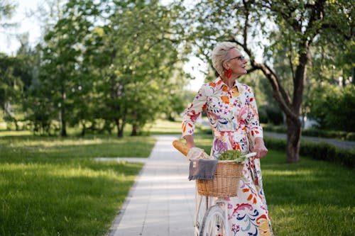 A Woman in Floral Dress Riding a Bike