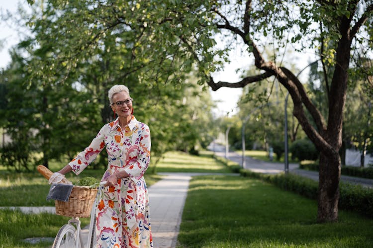 Pretty Senior Woman Walking With A Bicycle