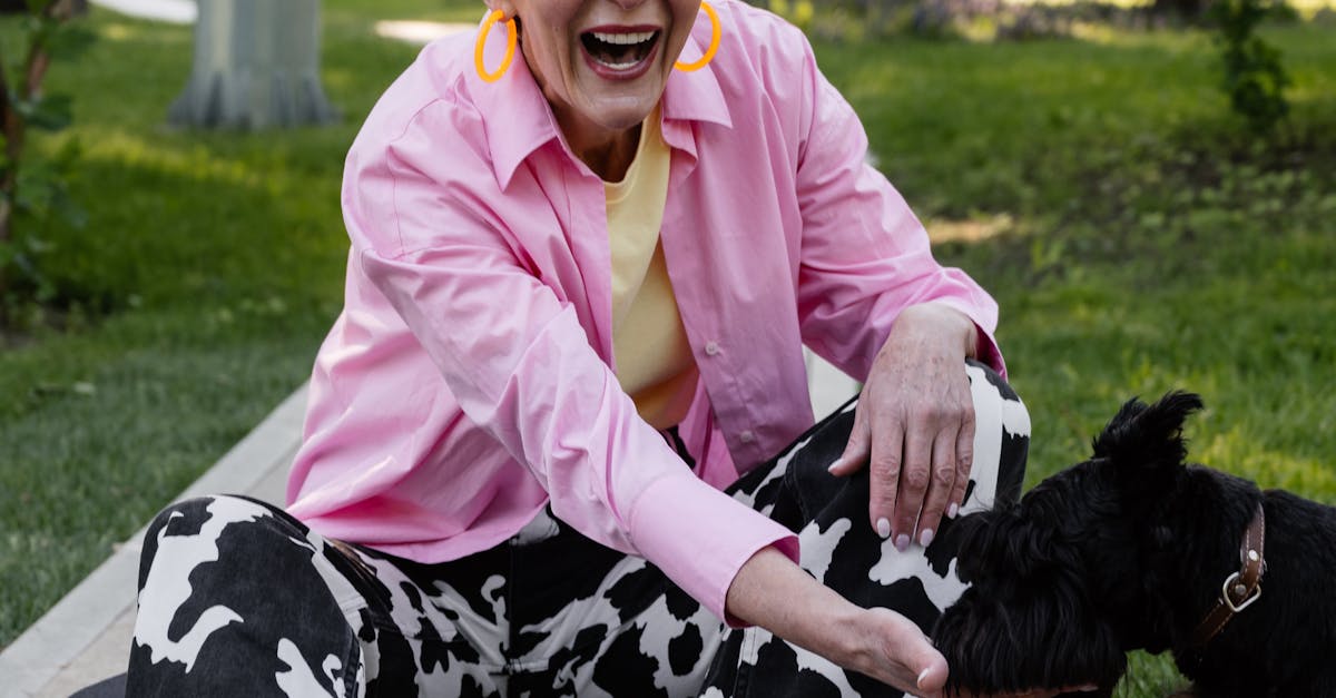 Senior Woman in Pink Long Sleeves Feeding a Dog
