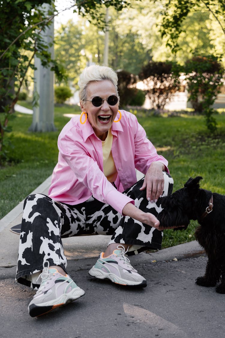 Senior Woman In Ping Long Sleeves Feeding A Dog